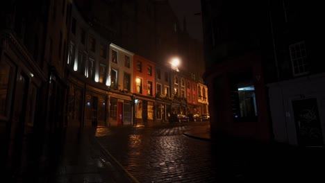 Person-walking-on-empty-Victoria-Street-in-Edinburgh-on-a-quiet-foggy-night