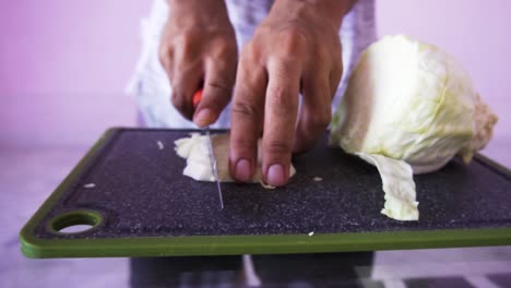 Young-man-cutting-cabbage-for-salad