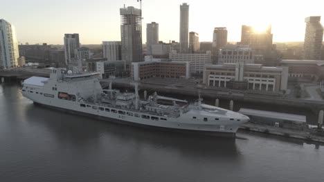 RFA-Navy-Tiderace-military-tanker-on-Liverpool-cityscape-waterfront-at-sunrise-slow-rising-aerial-view