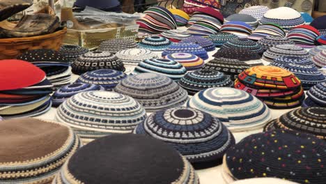 Variety-of-ornate-kippah-yarmulke-on-market-stall-many-designs-close-up