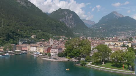 Beautiful-drone-view-of-the-north-italian-city-Riva-Del-Garda-with-the-lake-garda-in-the-foreground-and-the-alps-in-the-background