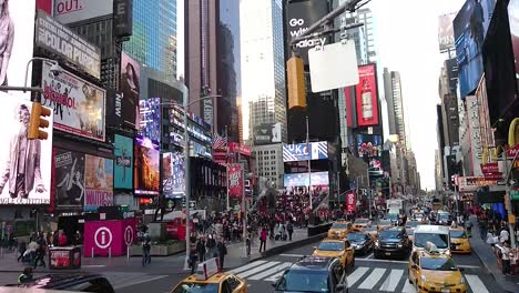 Crowded-NYC-Times-Square-with-yellow-cabs,-vehicles-and-tourists