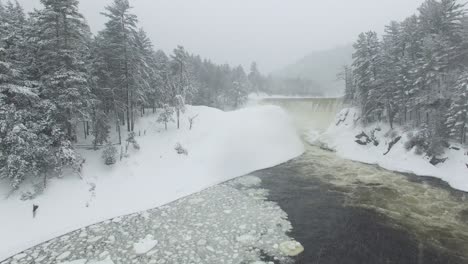 Drohne-Fliegt-Durch-Schneefall-In-Richtung-Der-Magischen-Winterlandschaft-Eines-Wasserfalls