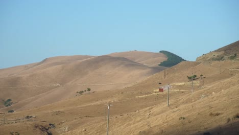 Windy-road-over-the-french-pass-in-New-Zealand-and-vast-dry-plains-under-a-blue-sky