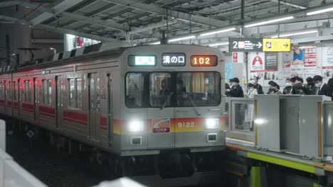 Zug-Mit-Passagieren,-Die-Sich-Dem-Bahnsteig-Des-Bahnhofs-In-Tokio,-Japan,-Nähern