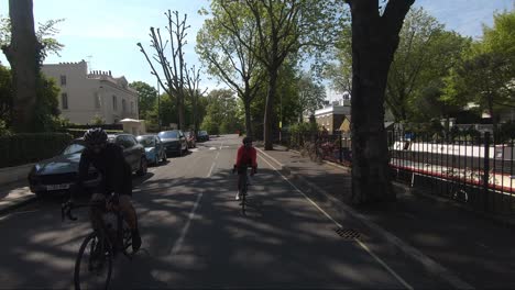 Two-Cyclists-Riding-Down-Maida-Avenue-In-Maida-Vale-During-Lockdown-In-London