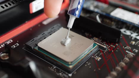 Ein-Computerreparaturtechniker-Installiert-Eine-AMD-Ryzen-2400G-CPU-Mit-Wärmeleitpaste-Auf-Einem-Motherboard