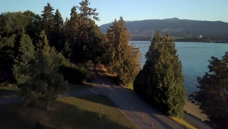 Un-Parque-Tranquilo-Y-Vacío-De-Stanley-Con-árboles-Verdes-Revela-El-Puente-Lions-Gate-Sobre-La-Entrada-Burrard-En-Vancouver,-Canadá