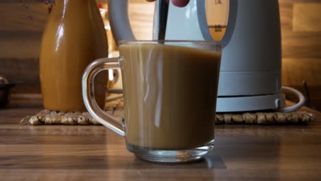 Stirring-a-mug-of-instant-white-coffee-in-close-up-side-shot