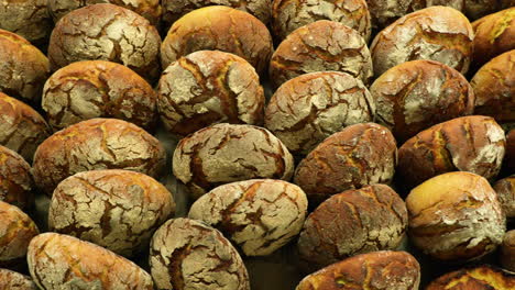 Bakery-Rack-Full-Of-Sourdough-Bread-Buns---top-view,-slider-shot