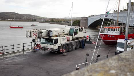 Hydraulisches-Kranfahrzeug,-Das-Ein-Fischerboot-Am-Hafen-Von-Conwy,-Wales,-Anhebt,-Rechts-Dolly
