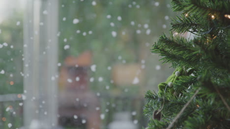 Snow-slowly-falling-down-outdoors-through-the-window-close-to-christmas-tree