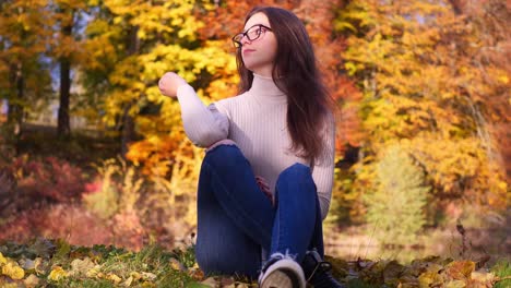 Slow-Motion-of-Teenage-Girl-in-Colorful-Autumn-Landscape,-Yellow-Tree-Leaf,-Pond-on-Sunny-Fall-Day