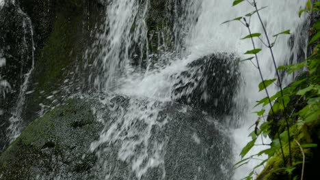 Nahaufnahme-Eines-Wassers-Aus-Einem-Wasserfall,-Der-Auf-Einen-Felsen-Trifft
