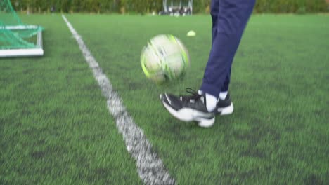Black-soccer-player-juggles-a-ball-on-a-football-field