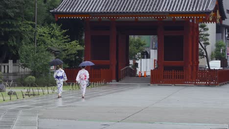 Zwei-Frauen-Im-Traditionellen-Japanischen-Kimono-Gehen-An-Einem-Regnerischen-Tag-In-Der-Nähe-Des-Senso-Ji-Schreins-In-Asakusa,-Tokio,-Spazieren