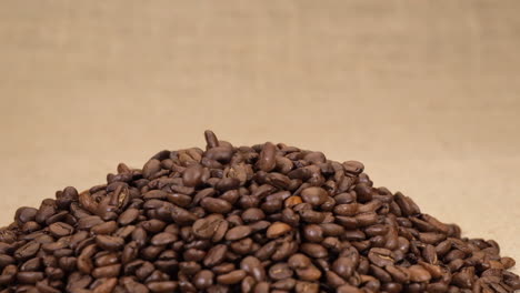Coffee-beans-arabica-falling-isolated-on-jute-background