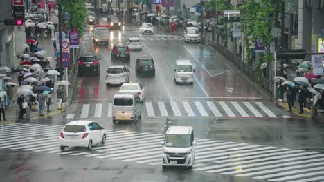Gente-Con-Sombrillas-Y-Escena-De-Tráfico-En-El-Cruce-De-Shibuya-En-Un-Clima-Lluvioso---Hiperlapso