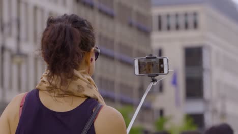 Mujer-Tomando-Selfie-Con-Smartphone-En-Monopod-Stick---Enfoque-Selectivo,-Cámara-Lenta