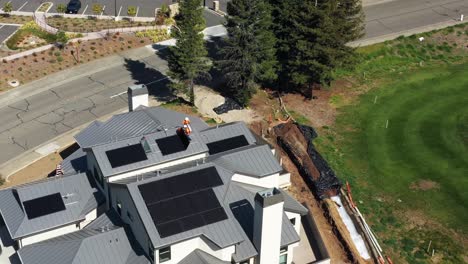 Luftaufnahme-Oben-Von-Männern,-Die-Sonnenkollektoren-Auf-Dem-Dach-Eines-Neuen-Hauses-Installieren