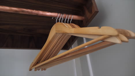 Close-up-of-wooden-coat-hangers-on-a-rail