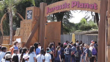 Elementary-Students-on-Field-Trip-at-Dinosaur-Exhibit,-Entering-Jurassic-Planet,-Slow-Motion