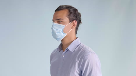 Man-in-Button-Up-Shirt-Puts-on-Face-Mask,-Angled-Profile-Closeup-Facing-Left
