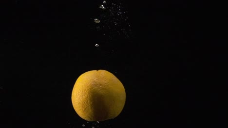 A-slow-motion-clip-of-an-orange-being-dropped-in-slow-motion-into-water
