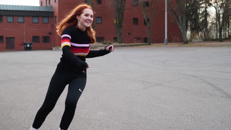Young-Happy-Red-Haired-Girl-Riding-Roller-Skates-on-Asphalt,-Slow-Motion