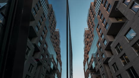 Reflektierendes-Spiegelglasgebäude-Vor-Blauem-Sonnenuntergangshimmel-Im-Barcode-Projekt,-Innenstadt-Von-Oslo,-Norwegen---Niedriger-Winkel,-Zeitraffer