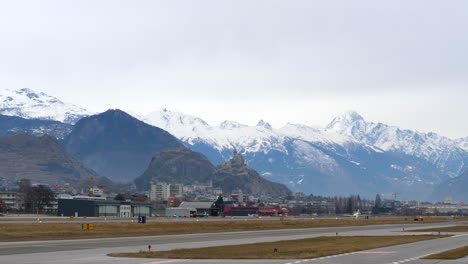 Distant-private-jet-taking-off-from-runway-at-Sion-Airport-in-the-alps