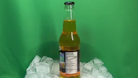 1-3-Kola-Champagner-Getränkeglasflaschen-Mit-Geschmack-Der-Marke-Grace,-Die-Sich-Um-360-Grad-In-Einer-Mit-Eis-Gefüllten-Schüssel-Vor-Einem-Grünen-Bildschirm-Drehen