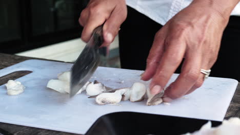 Recipe-preparation---Woman-with-ring-cut-squid-into-small-pieces,-cutting-white-board