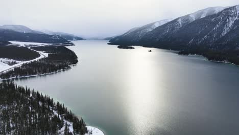 Muncho-Lake-wintery-landscape-in-snow,-aerial-drone-shot
