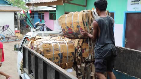 Hombre-En-Camión-Cargando-Montones-De-Cartón-Para-Reciclar-En-Indonesia---Plano-Medio