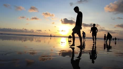 Siluetas-Jugando-En-La-Playa-Al-Atardecer-En-Bali,-Indonesia