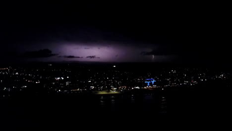 REALTIME-AERIAL-epic-shot-of-explosive-electrical-storm-over-a-city-at-night
