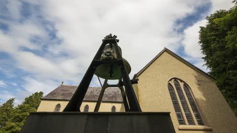 Time-lapse-of-a-historical-church-with-large-bell-on-a-pedestal-in-rural-countryside-of-Ireland-during-the-day