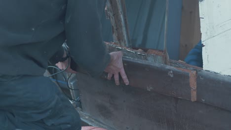 Carpenter-removes-section-of-rubbing-strake-on-eighty-year-old-wooden-boat