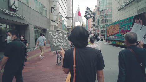 Manifestante-Sosteniendo-Un-Cartel-Contra-El-Ccp-En-Solidaridad-Con-La-Protesta-De-Hong-Kong-En-Tokio,-Japón---Vista-Posterior,-Plano-Medio
