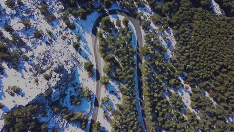 Aerial-view-of-a-cruved-road-in-a-snowed-moutain