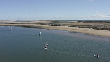 Windsurfers-enjoying-the-nice-weather-on-Fuseta-Island,-Portugal