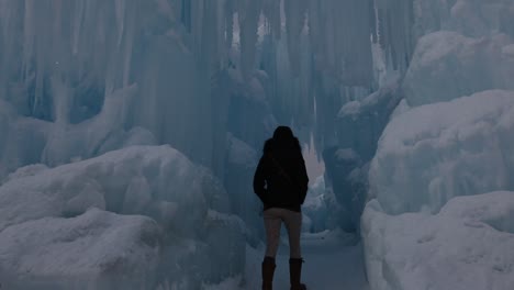 Person-walking-down-a-frozen-tunnel-of-ice-and-snow