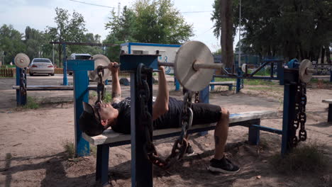 Man-bench-pressing-with-diy-iron-bar-and-weights
