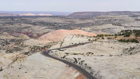 Slow-motion-shot-of-motorhome-driving-through-otherworldly-landscape-in-Utah,-USA