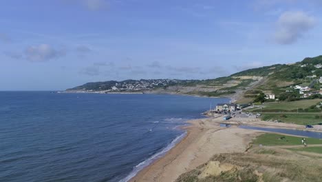 Static-aerial-across-the-beach-at-Charmouth,-Dorset