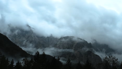 Time-lapse-of-clouds-over-mountain-peak,-dramatic-stormy-sky,-forest-in-foreground,-Ojstrica-peak-in-Kamnisko-Savinjske-Alpe,-Logarska-dolina,-Slovenia,-European-Alps