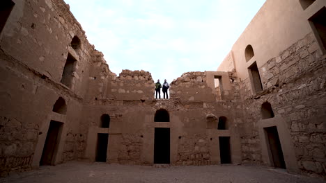 Eingang-Der-Wüstenburg-Qasr-Kharana-Mit-Zwei-Touristen,-Die-Im-Zweiten-Stock-Der-Burg-Stehen