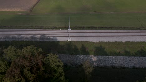 Fast-moving-aerial-shot-of-an-empty-railway-in-the-Slovenian-countryside-near-farmland