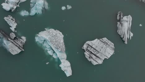 Vista-Aérea-Directamente-Sobre-Icebergs-En-Una-Laguna